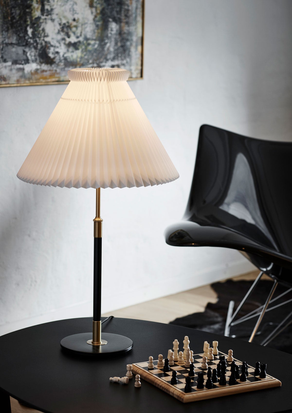 En tänd Le Klint 352 Bordslampa på soffbord med schackbräde