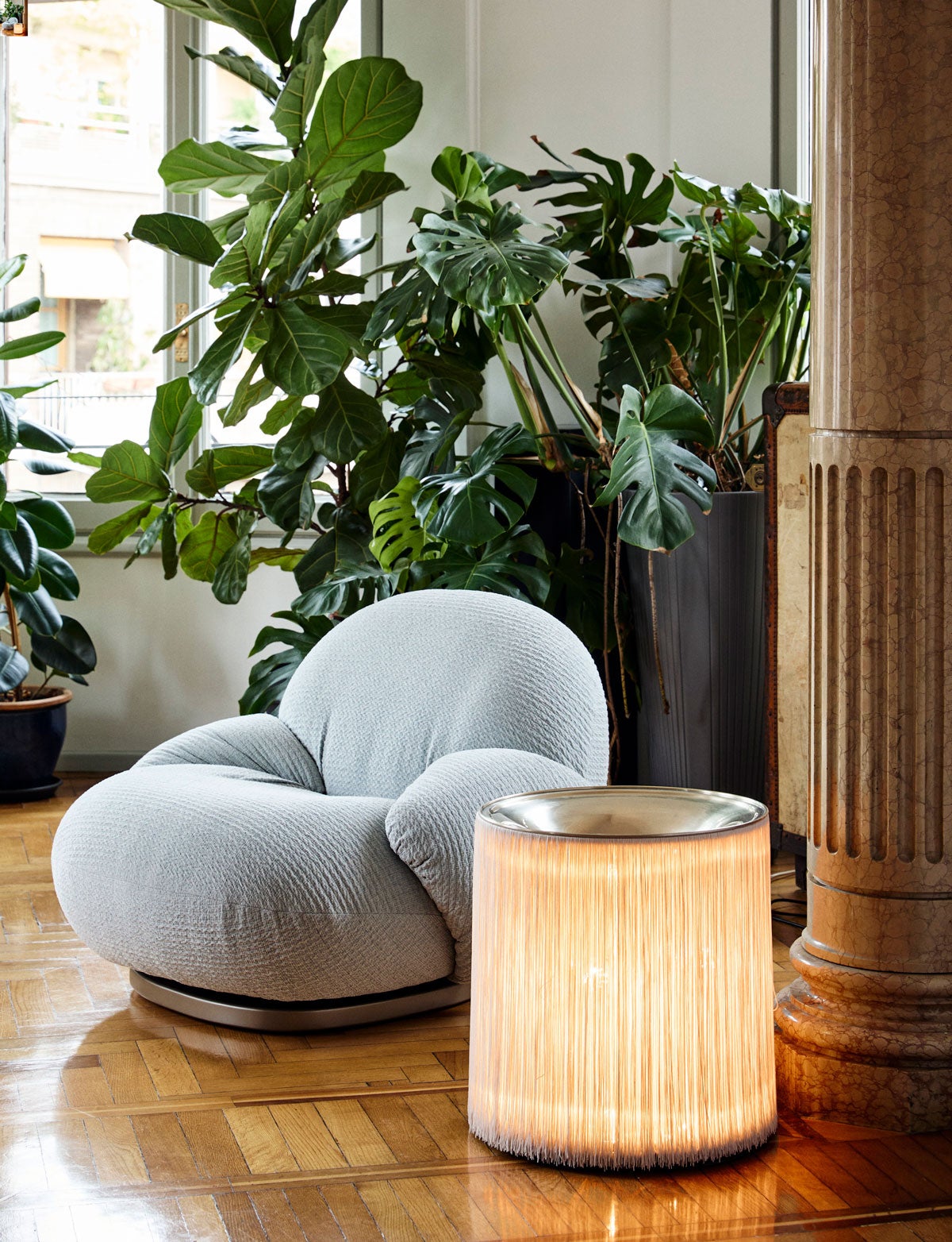 Model 597 Golvlampa bredvid Pacha Loungefåtölj i vardagsrum med gröna växter