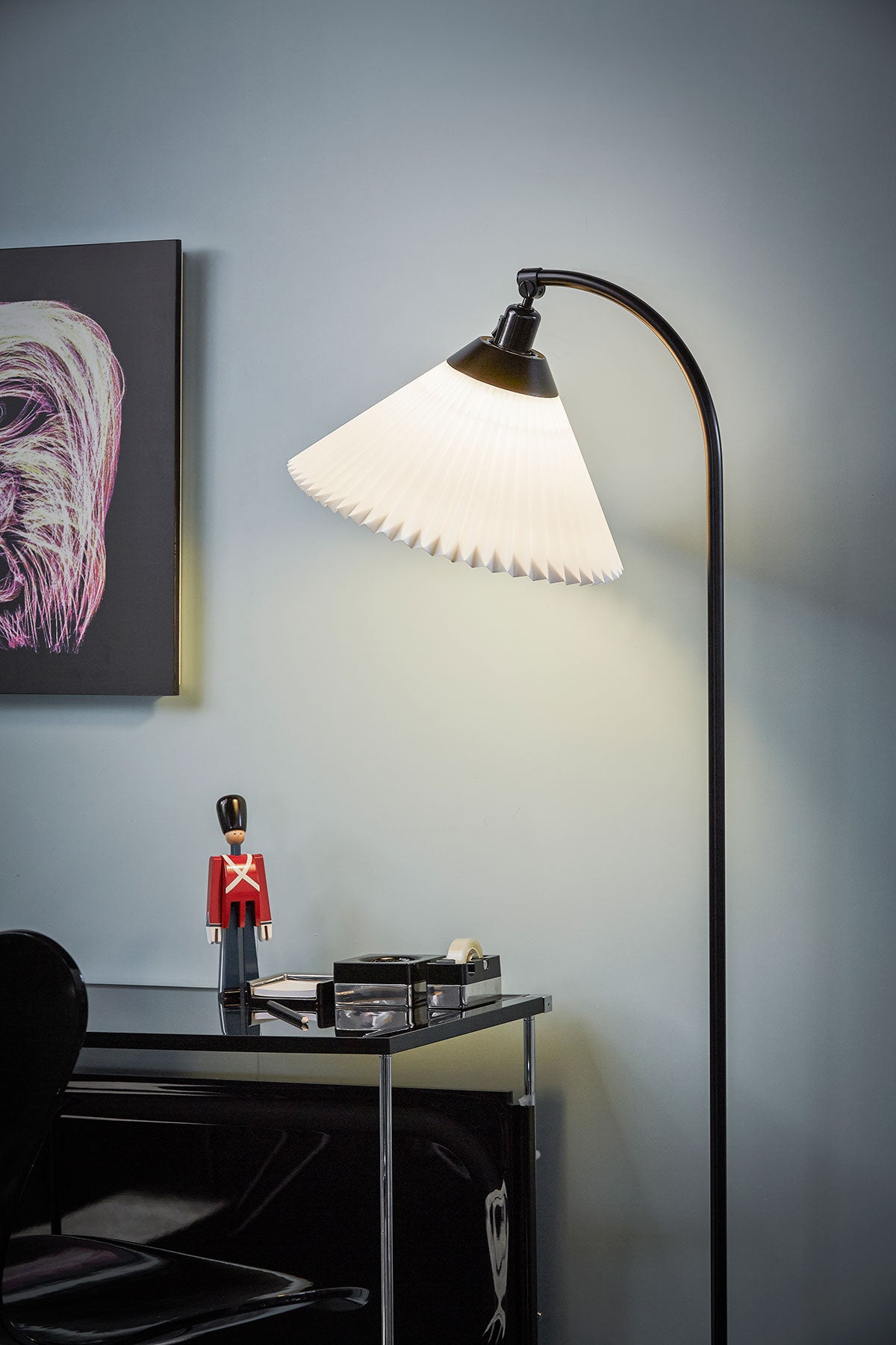 En tänd Le Klint 368 Golvlampa riktad mot ett sidobord